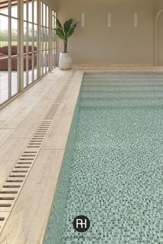 an indoor swimming pool with tiled flooring and glass doors leading to the upper level