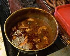 a pot filled with food sitting on top of a stove next to pretzels