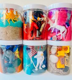 four plastic jars filled with different types of toys