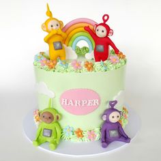 a birthday cake decorated with monkeys and rainbows