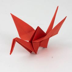 an origami bird is shown on a white surface with no one around it