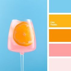 an orange and pink drink in a wine glass on a blue background with color swatches