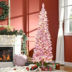 a pink christmas tree in front of a fireplace with presents on the floor next to it