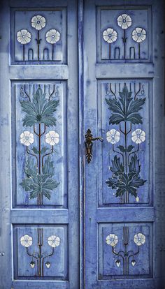 an ornate blue door with flowers painted on it