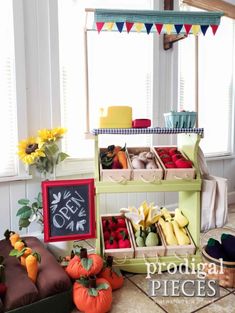 an assortment of fruits and vegetables on display in front of windows with sunflowers