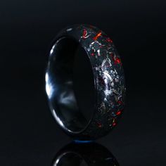 a black ring with red and yellow splatkles on the inside of it