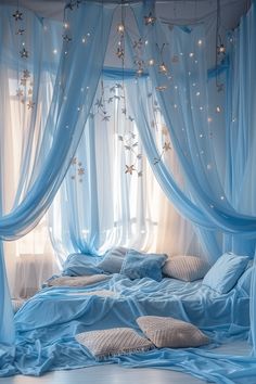 a bed with blue sheets and lights hanging from the ceiling