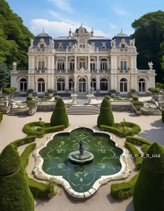 a large white building with a fountain in the middle and lots of trees around it