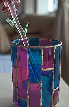 a vase with a flower in it sitting on a table