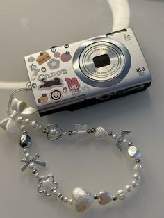 a camera is sitting on top of a table next to a beaded bracelet and necklace