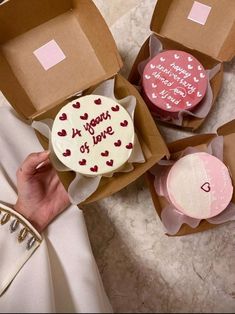 a person is holding some cupcakes in boxes