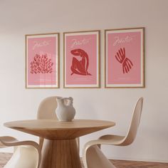 two pink posters on the wall above a table