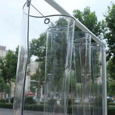 three clear glass vases sitting on top of a wooden table next to a street