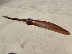 a wooden propeller sitting on the ground