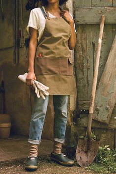 a woman wearing an apron and holding a shovel