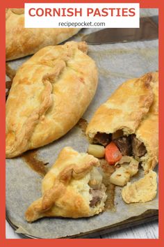 two pastries with meat and vegetables are on a baking sheet, one has been cut in half