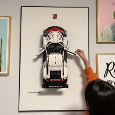 a woman pointing at a lego model of a semi - truck in front of some pictures