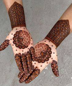 two hands with henna designs on them