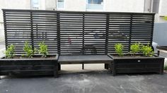 an outdoor bench made out of pallets with plants growing on it and attached to the wall