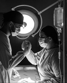 a man and woman in scrubs standing next to each other with medical equipment around them