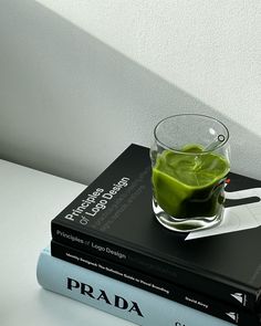 two books are stacked on top of each other and one is filled with green liquid