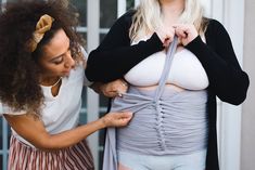 two women are trying to figure out what's in the bra and how it looks like