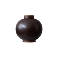 a brown vase sitting on top of a white wall