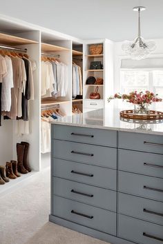 a walk in closet filled with lots of clothes and shoes next to a counter top