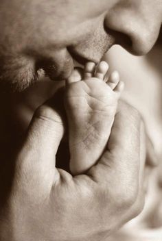 a black and white photo of a man holding a baby