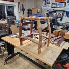 a wooden chair sitting on top of a table in a room filled with other furniture