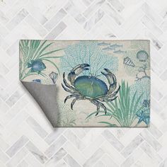 a blue crab and seaweed rug on a white tile floor