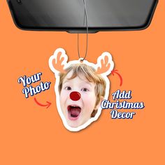 a child's face hanging from the side of a car mirror with an ornament attached to it