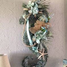 a wreath is hanging on the wall next to a lamp