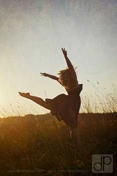 a woman is jumping in the air while wearing a dress and holding her arms out