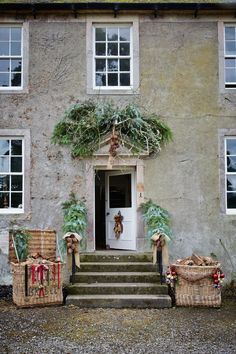 an old house with christmas wreaths on the front door and steps leading up to it