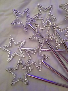 some silver colored metal pins and needles on a white sheet with beaded stars in the middle