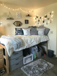 a bed with lots of pillows on top of it next to a desk and drawers