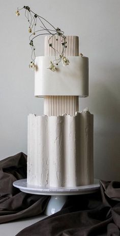 a three tiered white cake with flowers on top