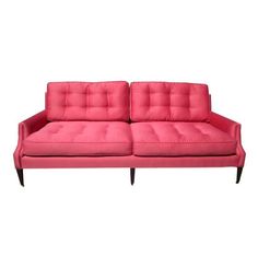 a pink couch sitting on top of a white floor