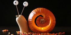 a snail carved into a pumpkin with the word love spelled in front of it and two eyes on each side