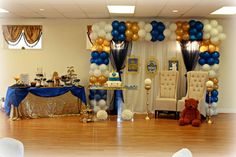 a party room with balloons and decorations on the wall, chairs, table and teddy bear