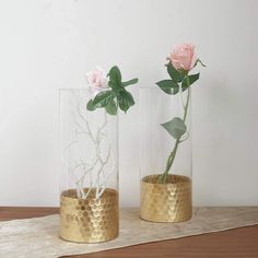 two vases with flowers in them sitting on a table