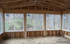 an empty room with three windows and no insulation on the walls, in front of some trees