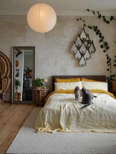 a cat sitting on top of a bed in a bedroom