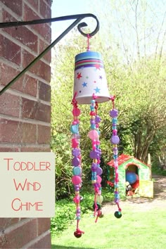 a child's wind chime hanging from a brick wall