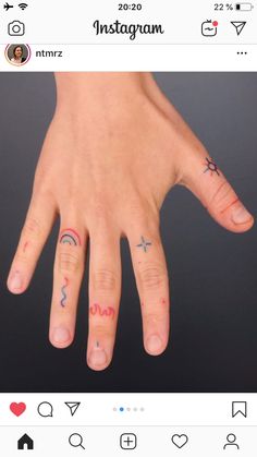 two fingers with different tattoos on them