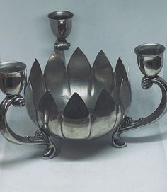 a silver vase with three candles in it