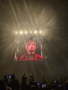 a man on a large screen at a concert