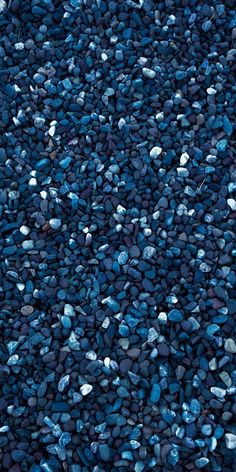 blue rocks are scattered on top of each other in an area that looks like it is covered with gravel