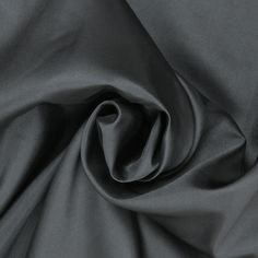 Elevate your creations with our exquisite Black Solid Mikado fabric. Renowned for its luxurious sheen and structured finish, Mikado is a blend of silk and nylon that offers both elegance and versatility. The deep, rich black hue adds an element of sophistication to any garment, making it a popular choice for eveningwear, bridal gowns, and formal attire. This fabric's substantial weight and crisp texture provide the perfect drape, ensuring that your designs maintain their shape and elegance throu Fitted Solid Color Fabric For Formal Occasions, Fitted Solid Fabric For Formal Wear, Fitted Silk Fabric For Party, Elegant Silk Fabric For Evening, Elegant Silk Fabric For Formal Occasion, Formal Solid Fitted Fabric, Elegant Evening Silk Fabric, Elegant Black Party Fabric, Elegant Silk Fabric With Satin Finish